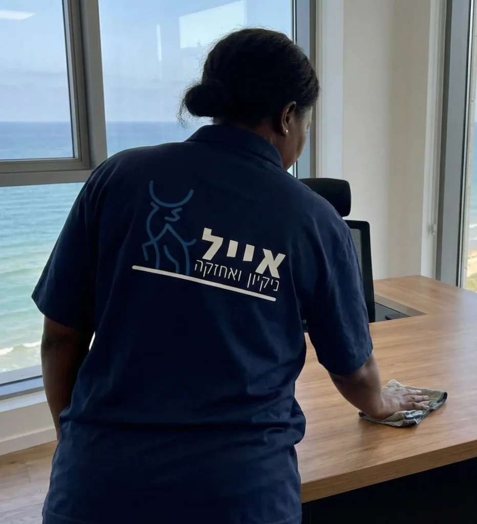 עובדת מנגבת שולחן משרדי